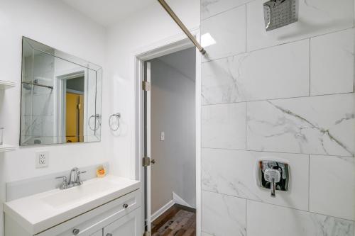 a white bathroom with a sink and a mirror at Charming Roanoke Vacation Home - 1 Mi to Downtown! in Roanoke