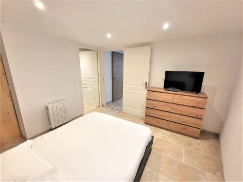 1 dormitorio con cama y vestidor con TV en Joli T2 1er étage wifi/verdon/centre ville, en Castellane
