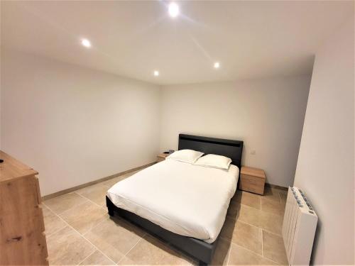 1 dormitorio con 1 cama con sábanas y almohadas blancas en Joli T2 1er étage wifi/verdon/centre ville, en Castellane