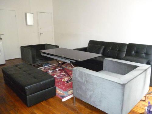 un salon avec un canapé noir et une table dans l'établissement Beautiful 4 people flat in Paris, Bastille, à Paris