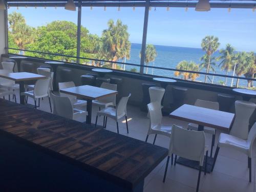 a restaurant with tables and chairs and a view of the ocean at HOTEL BLUE MALECÓN in Santo Domingo