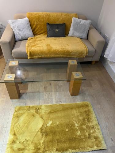 a living room with a couch and a yellow rug at Stonebarn Lane in Halton