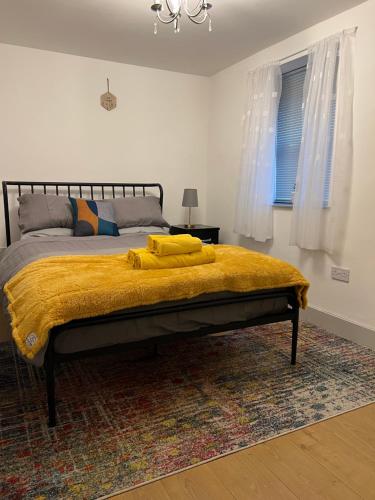 ein Schlafzimmer mit einem Bett mit einer gelben Decke darauf in der Unterkunft Stonebarn Lane in Halton