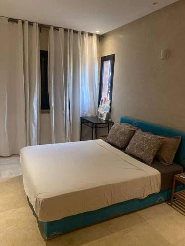 een slaapkamer met een groot bed voor een raam bij Villa Soleil 4 chambres in Marrakesh