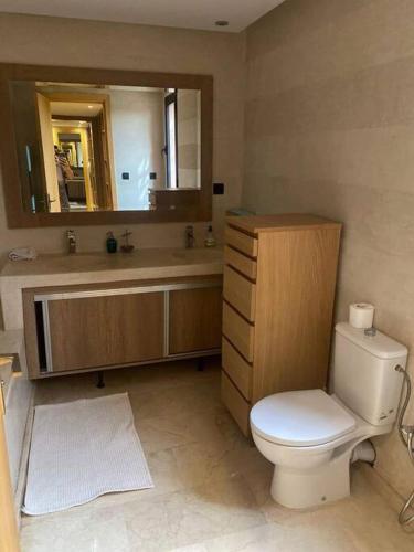 a bathroom with a toilet and a sink and a mirror at Villa Soleil 4 chambres in Marrakesh