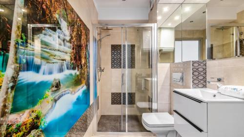 een badkamer met een douche en een schilderij aan de muur bij BALTIC PARK A Apartamenty PIAMOLA in Stegna