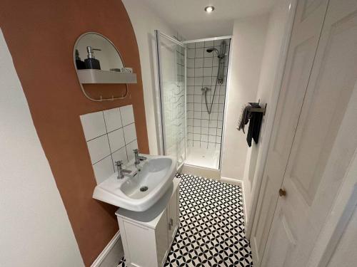 a white bathroom with a sink and a shower at Cozy 1 Bedroom Flat The Snug in Kent