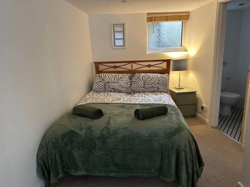 una camera da letto con un letto con una coperta verde di Cozy 1 Bedroom Flat The Snug a Kent