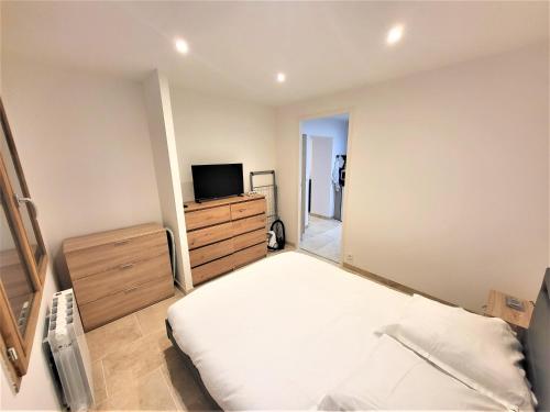1 dormitorio con cama y vestidor con TV en T2 RDC neuf/wifi/centre village, en Castellane