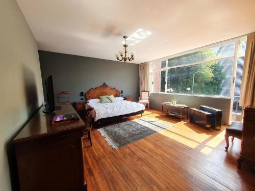 a bedroom with a bed and a large window at Lindas Suites Eugenio Sue in Mexico City
