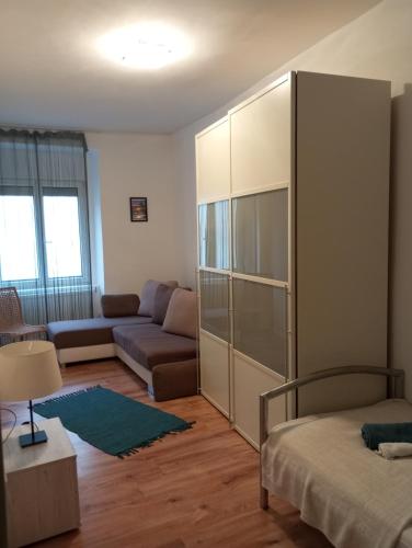 a living room with a bed and a couch at Milla Apartmanok in Eger