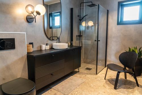 een badkamer met een wastafel en een douche bij Skipperhuset leilighet nr 1 in Tofta