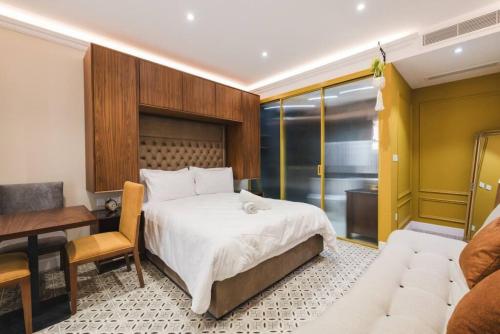 1 dormitorio con cama, escritorio y sofá en Zebbuga Deluxe Balcony Suite Apartment 4, en Żebbuġ