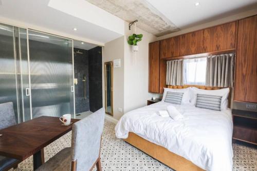 a bedroom with a bed and a wooden wall at Iz-Zebbuga The Penthouse Royal 8 in Żebbuġ