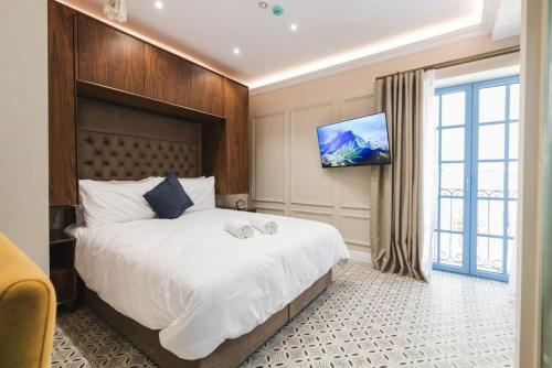 a bedroom with a large bed and a flat screen tv at Zebbuga Deluxe Balcony Apartment 6 in Żebbuġ