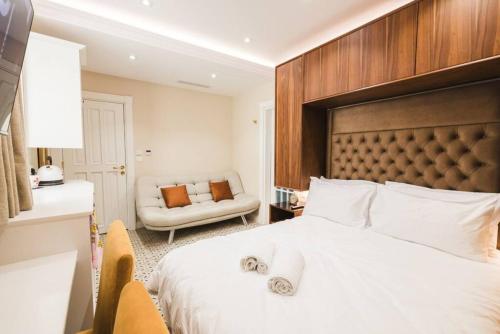 a bedroom with a large white bed and a chair at Zebbuga Deluxe Lavish Suite 3 in Żebbuġ
