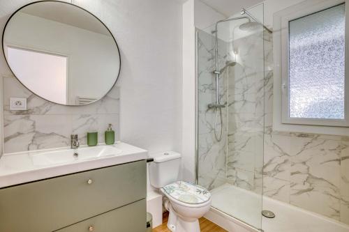 een badkamer met een wastafel, een toilet en een spiegel bij Élégant studio centre Marmande Mon Petit Appart in Marmande