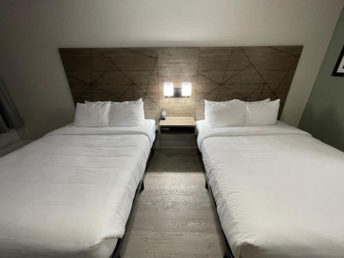 two beds sitting next to each other in a room at Quality Inn & Suites Airport-Cruise Port Hollywood in Hollywood