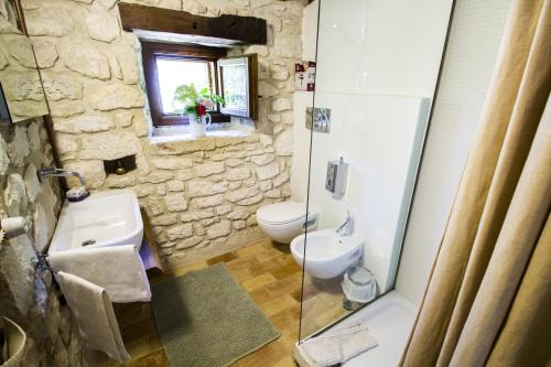a stone bathroom with a sink and a toilet at One bedroom apartement with enclosed garden and wifi at Abbateggio in Abbateggio