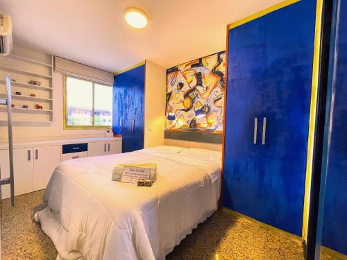 a bedroom with a large bed with a blue door at Apto no condomínio Life Resort 5 min/Esplanada dos Ministérios in Brasilia