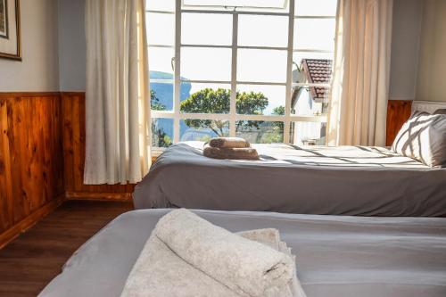 a bedroom with two beds and a large window at Panorama Chalets & Rest Camp in Graskop