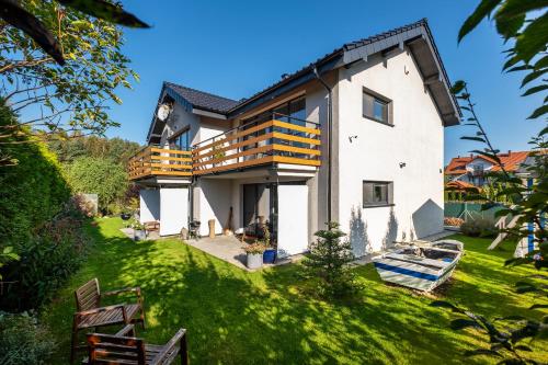 een groot huis met een balkon op een groen gazon bij Mado in Władysławowo