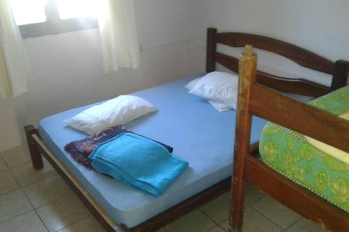 Una cama con dos almohadas y una bolsa azul. en Chalet Milagros, en Costa Azul