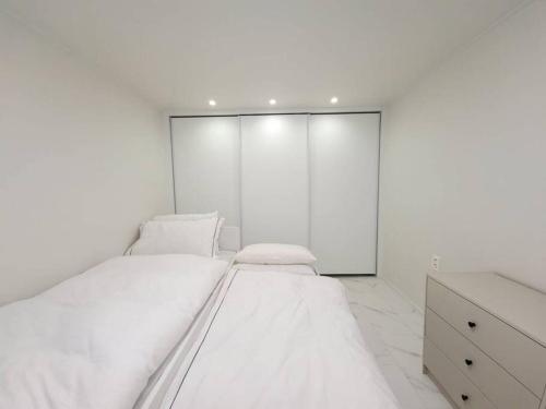 a white bedroom with two beds and a dresser at BridgeStar001 Gangnam Sinsa Station Garosugil 6 Guests in Seoul