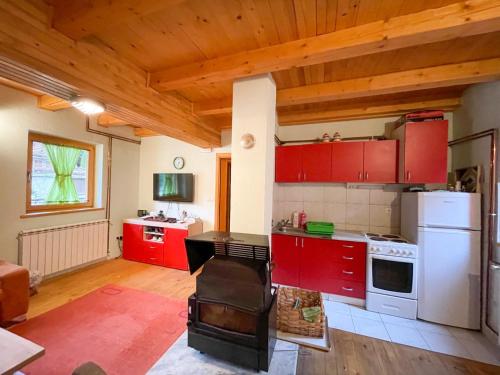 a kitchen with red cabinets and a white refrigerator at Holiday home Bella Vlašić in Šišava