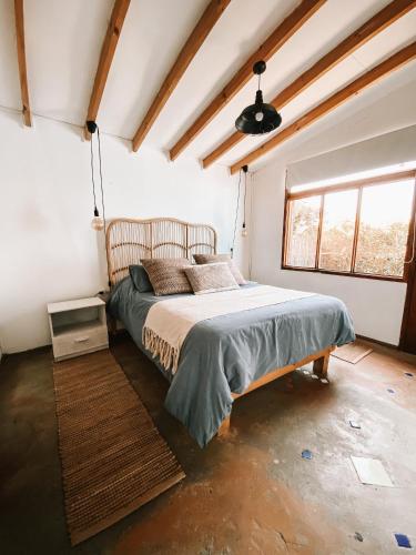 1 dormitorio con 1 cama en una habitación con ventana en Malibu Hostal Boutique, en Maitencillo