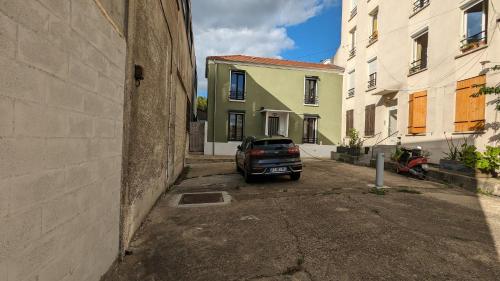 a car parked in an alley between two buildings at "Maison verte" - terrasse - parking - 10min du métro in Montreuil
