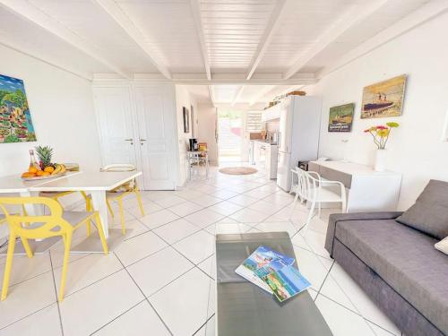a living room with a couch and a table at Plage 37 Orient Bay beach front with pool access in Orient Bay