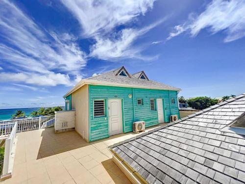 a blue house on top of a roof at Plage 37 Orient Bay beach front with pool access in Orient Bay