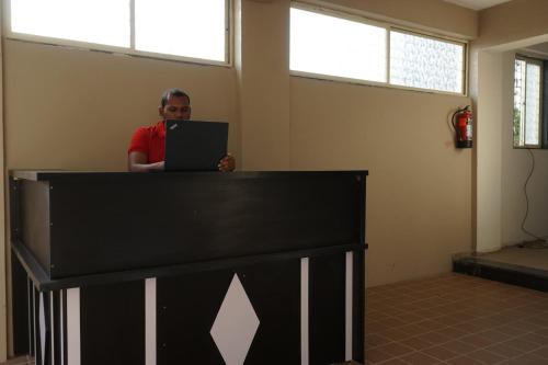 un homme debout derrière un comptoir avec un ordinateur portable dans l'établissement Arusai, à Méribel Village