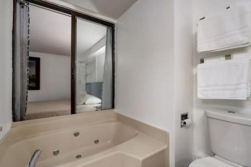 a bathroom with a tub and a toilet and a mirror at Lighthouse Retreat II for Location and Romance in Wisconsin Dells