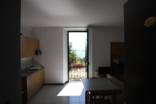 a kitchen with a door to a balcony with a view at Hotel La Pergola in Moniga