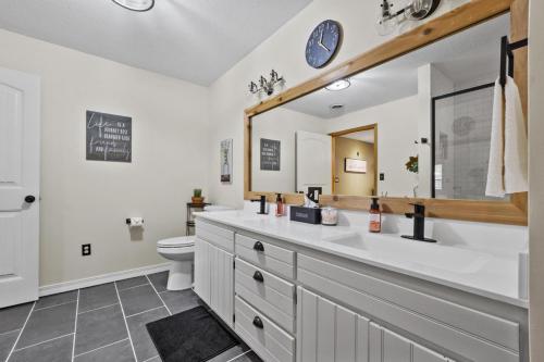 ein Badezimmer mit einem Waschbecken, einem WC und einem Spiegel in der Unterkunft Quiet Country Escape 