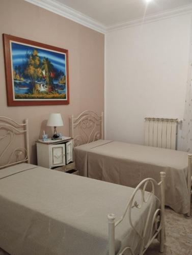 a room with two beds and a painting on the wall at Arancia e Cannella in Massafra