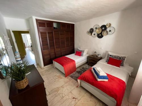 a bedroom with two beds with red and white sheets at AD house on Carvoeiro in Carvoeiro