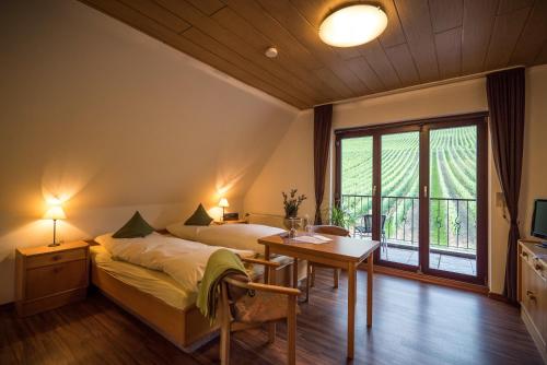 Schlafzimmer mit einem Bett, einem Schreibtisch und einem Fenster in der Unterkunft Weingut Peifer in Traben-Trarbach