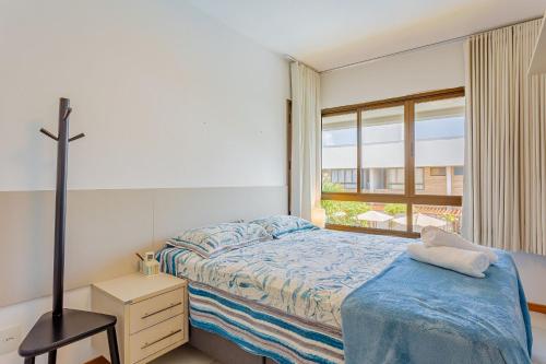 Camassari的住宿－IT08 Apto 3/4 a 50m da Praia - Itacimirim，一间卧室设有一张床和一个窗口
