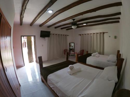 a bedroom with two beds with white sheets at Villas Marilu in Holbox Island