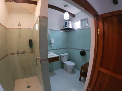 a bathroom with a shower and a toilet and a sink at Villas Marilu in Holbox Island