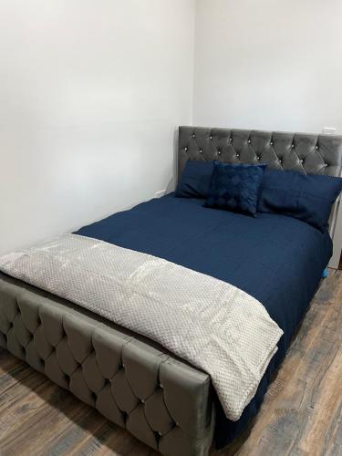 a large bed with blue sheets and blue pillows at Stonebarn Lane One Bed in Halton