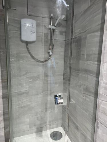 a shower with a glass door in a bathroom at Stonebarn Lane One Bed in Halton