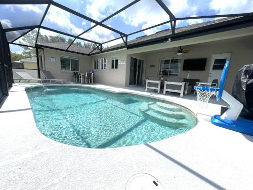 una gran piscina con un aro de baloncesto y un aro de baloncesto en Luxury Modern Pool House close to theme parks. en Kissimmee