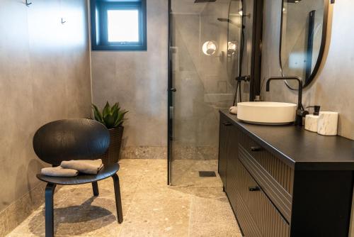 y baño con silla, lavabo y ducha. en Skipperhuset leilighet nr 2, en Tofta