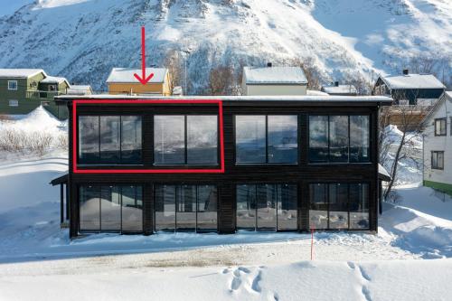 una casa en la nieve con un rojo X en ella en Skipperhuset leilighet nr 2, en Tofta