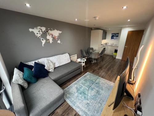 a living room with a couch and a world map on the wall at Perfect-City Centre-Apartment in Birmingham