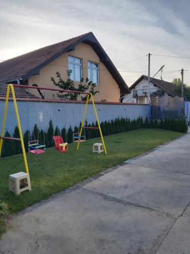 a yard with a swing set in front of a house at Olymp Apartmani in Kladovo